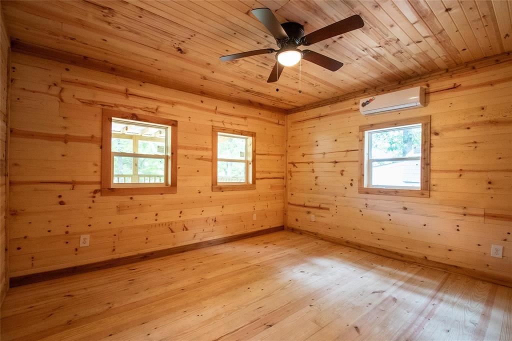 111 Ridgewood Lane Murchison, TX 75778 - Photo 25 of 36 Bedroom 2 with wood walls, floors, trim, and ceilings