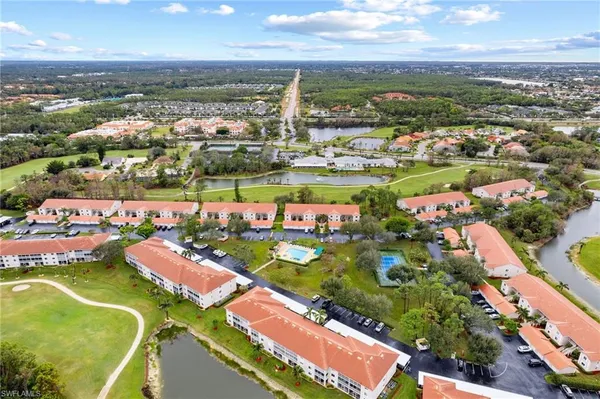 an aerial view of a city with lots of residential buildings ocean and mountain view in back