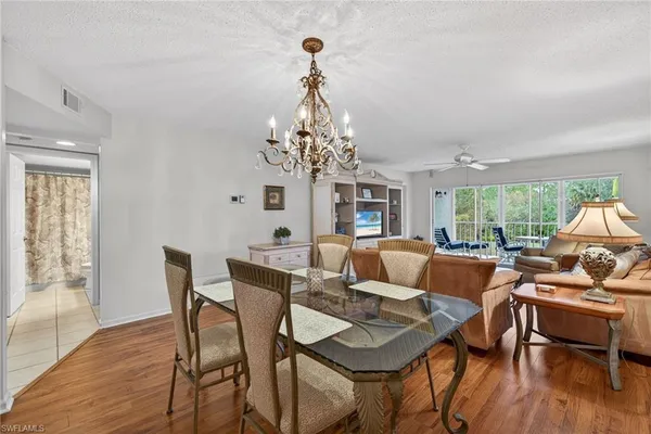 a view of a dining room with furniture wooden floor and chandelier