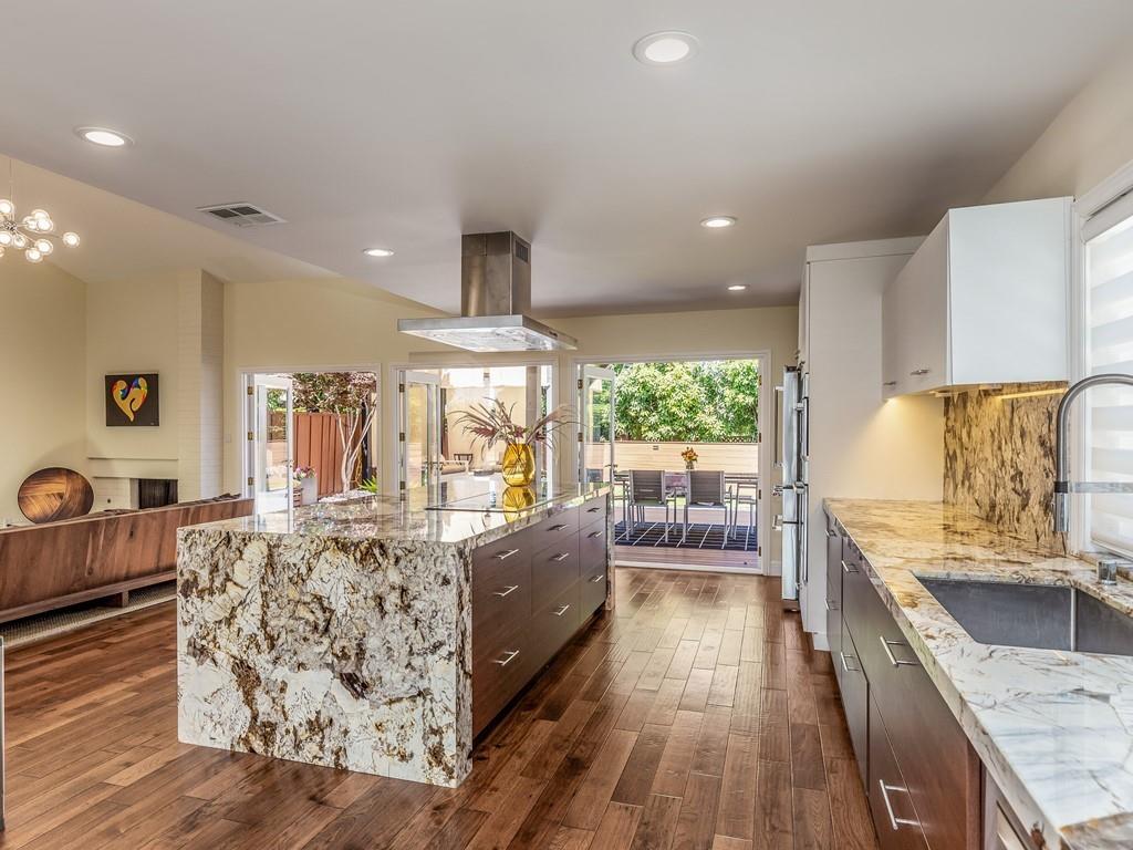 a large kitchen with stainless steel appliances kitchen island granite countertop a large window
