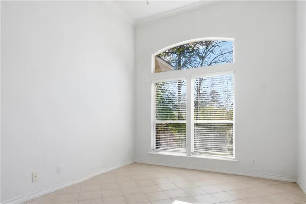 a spacious bedroom with a large bed and a chandelier