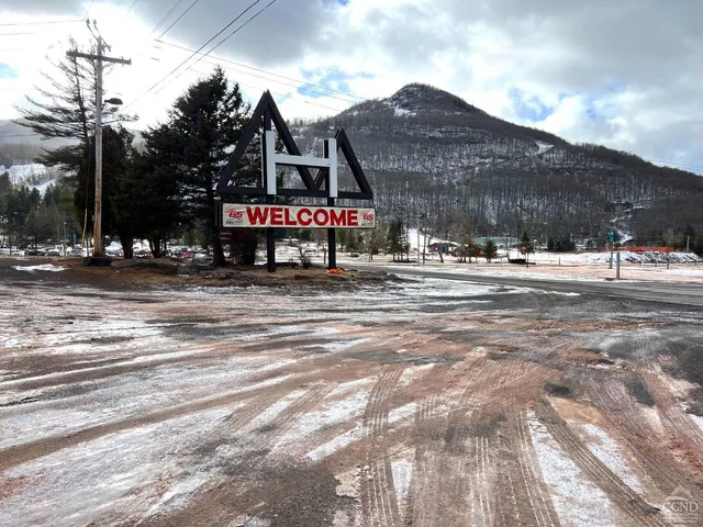 a sign board with buildings in the background