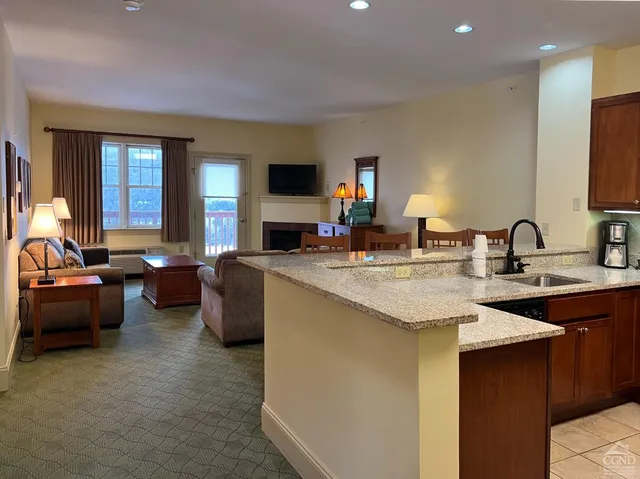 a kitchen with sink and living room