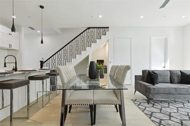 a living room with furniture and a dining table with wooden floor