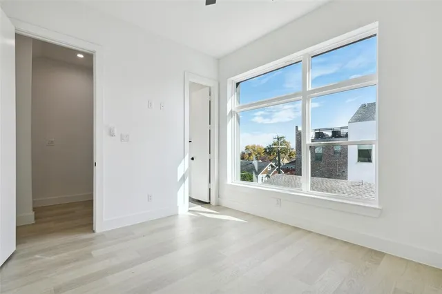 an empty room with wooden floor and a window
