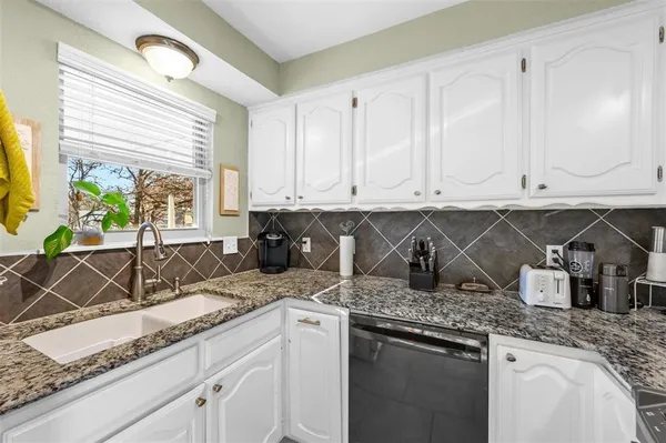 a kitchen with stainless steel appliances granite countertop a sink a stove and cabinets