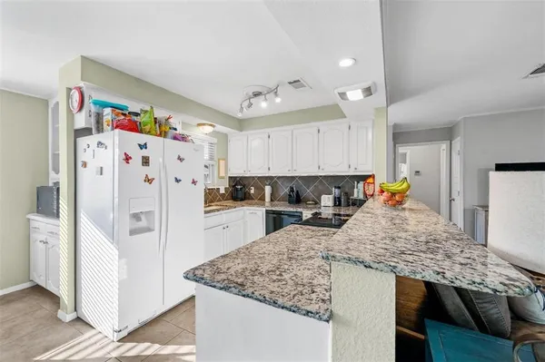 a kitchen with stainless steel appliances granite countertop a refrigerator and a stove top oven