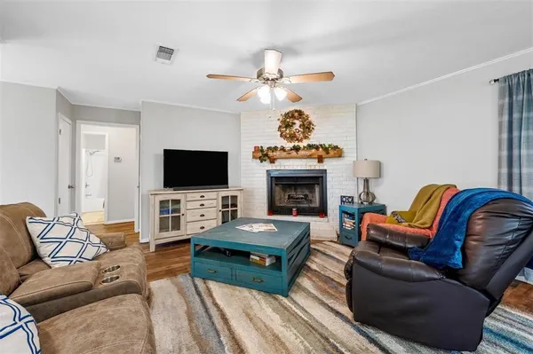 a living room with furniture a flat screen tv and a fireplace