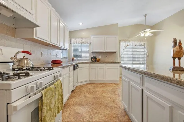 a kitchen with white cabinets and white appliances