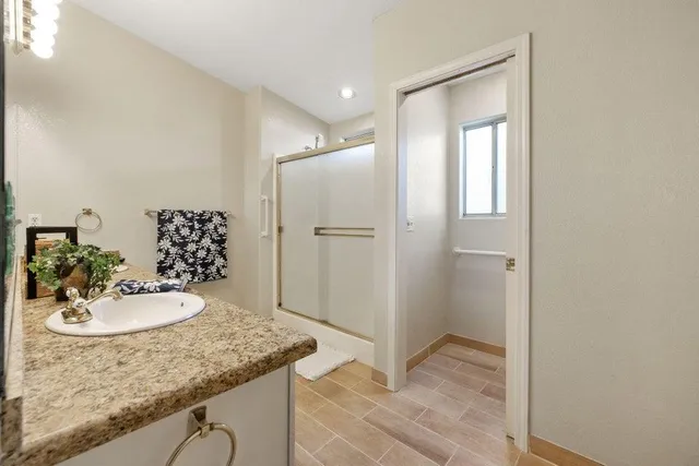 a spacious bathroom with a granite countertop sink and a mirror
