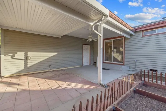a view of a backyard with wooden fence and trees