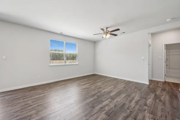 an empty room with fan and windows