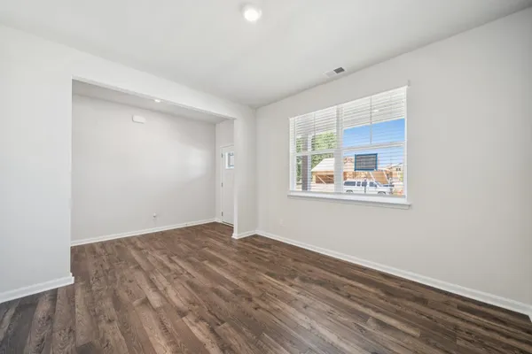 a view of an empty room with wooden floor