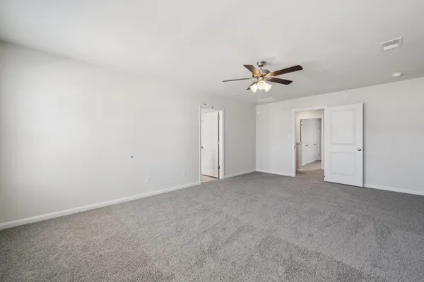 an empty room with windows and a ceiling fan