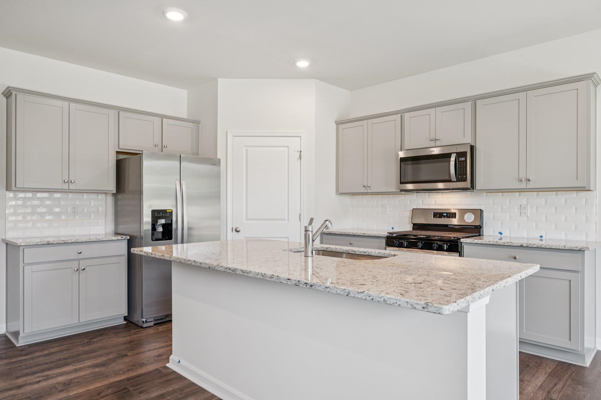 101 Stonewall Jackson Road Waynesboro, VA 22980 - Photo 3 of 30 a kitchen with granite countertop a refrigerator sink and white cabinets