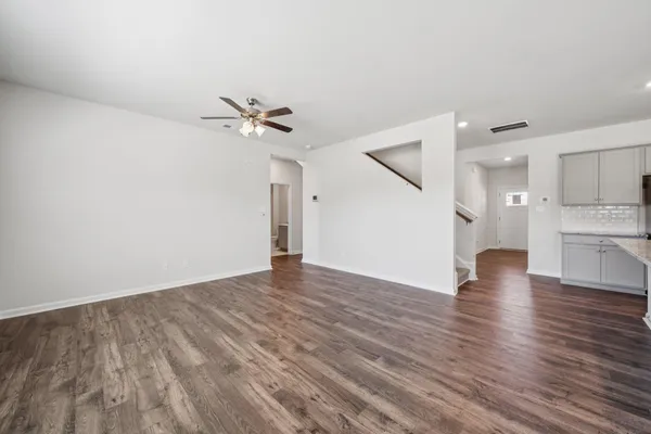 a view of a kitchen with wooden floor and a ceiling fan