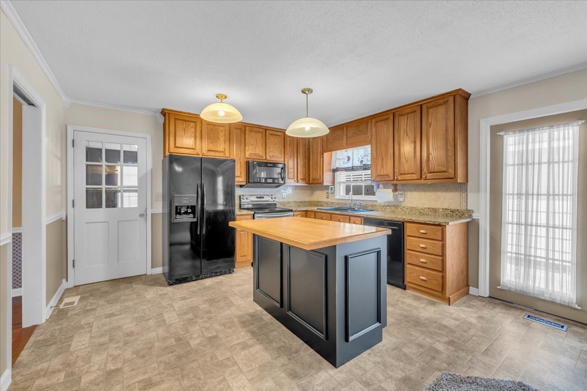 1587 Bypass Road Winchester, TN 37398 - Photo 16 of 26 a kitchen with stainless steel appliances granite countertop a stove a sink dishwasher a refrigerator and a fireplace with wooden floor