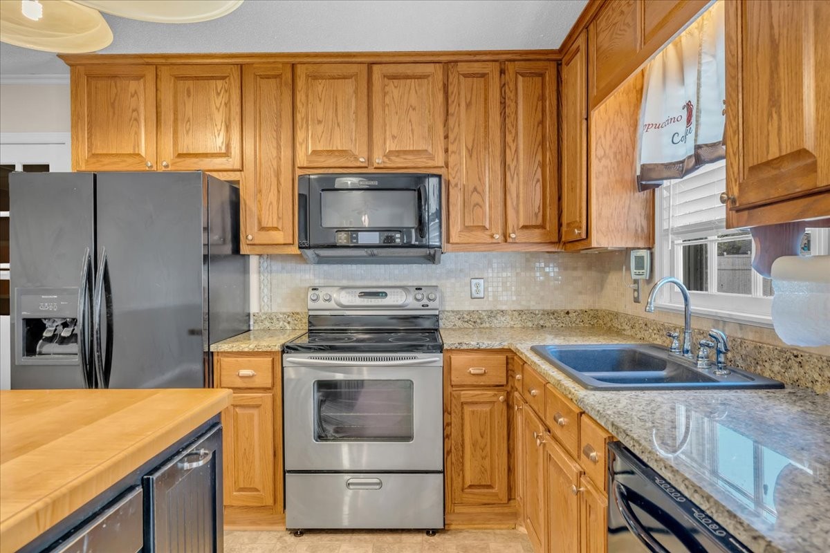 1587 Bypass Road Winchester, TN 37398 - Photo 18 of 26 a kitchen with granite countertop wooden cabinets stainless steel appliances and a window