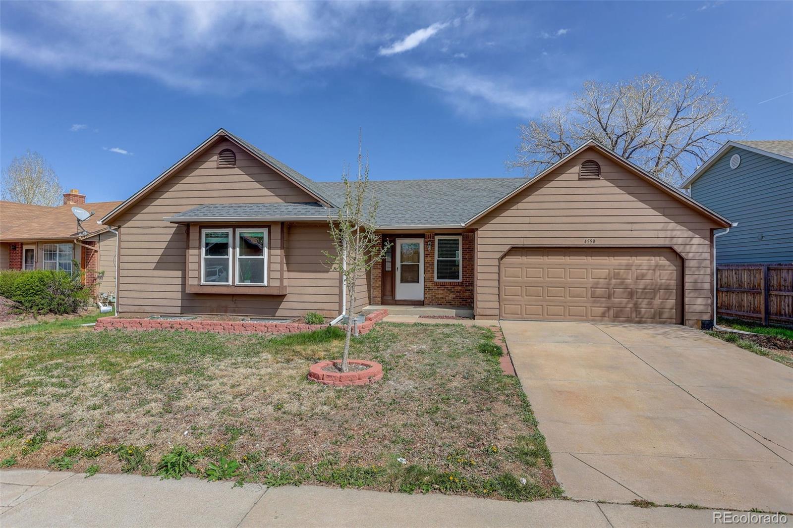 4550 Eugene Way Denver, CO 80239 - Photo 2 of 21 a front view of a house with a yard and garage