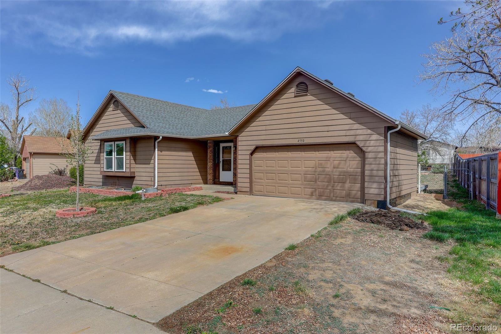 4550 Eugene Way Denver, CO 80239 - Photo 21 of 21 a front view of a house with a yard and garage