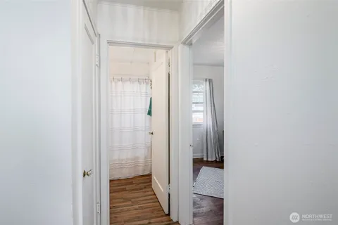 a view of a hallway with wooden floor and closet