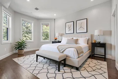 a bedroom with a large bed and a potted plant