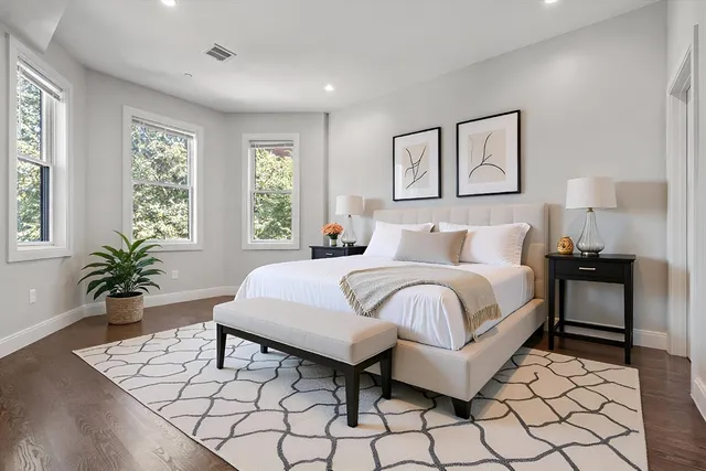 a bedroom with a large bed and a potted plant
