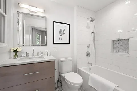 a bathroom with a toilet a sink a mirror a bathtub and shower