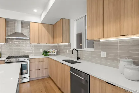 a kitchen with a sink a counter space appliances and cabinets