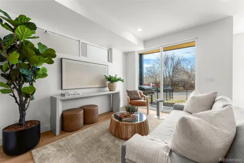 a living room with furniture a fireplace and a floor to ceiling window