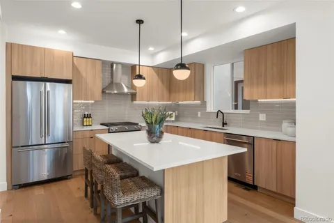 a kitchen with a table chairs stove a sink dishwasher and cabinets