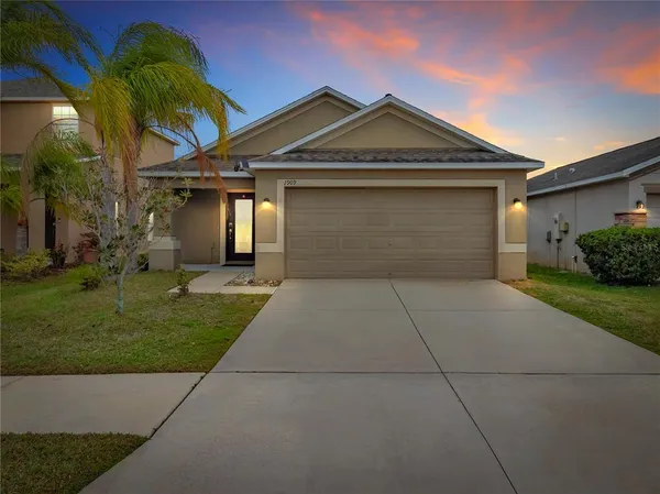 a front view of a house with a yard and garage