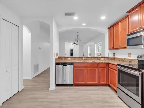 a large kitchen with stainless steel appliances granite countertop a stove and a sink