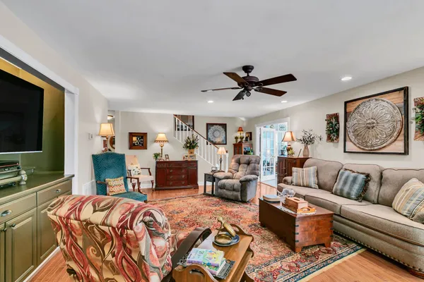 a living room with furniture kitchen view and a flat screen tv