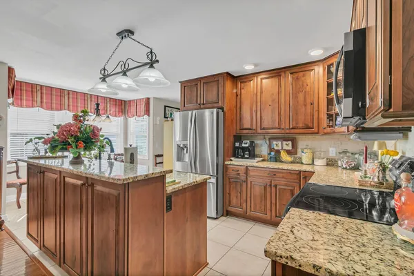 a kitchen with stainless steel appliances granite countertop a sink dishwasher a refrigerator and a stove