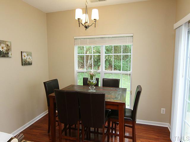 1127 Lake Moraine Place Raleigh, NC 27607 - Photo 11 of 23 a view of a dining room with furniture window and wooden floor