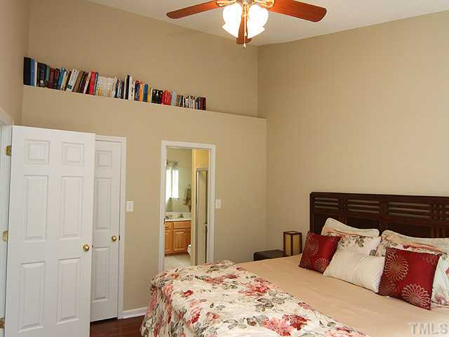 1127 Lake Moraine Place Raleigh, NC 27607 - Photo 14 of 23 a bedroom with a bed and a chandelier