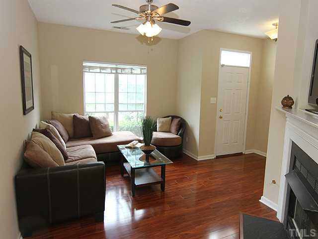 1127 Lake Moraine Place Raleigh, NC 27607 - Photo 3 of 23 a living room with furniture a fireplace and a flat screen tv