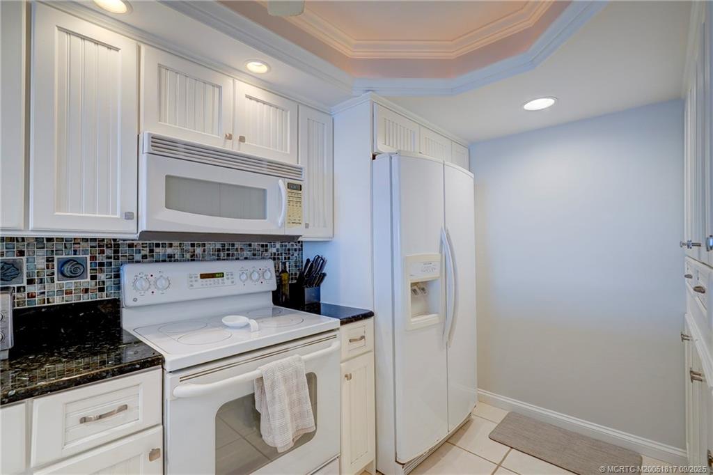 10 Northeast Plantation Road, Unit 203 Stuart, FL 34996 - Photo 15 of 50 a kitchen with white cabinets and white appliances