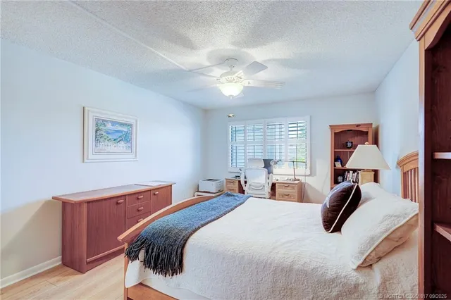 a bedroom with a bed and a dresser with wooden floor