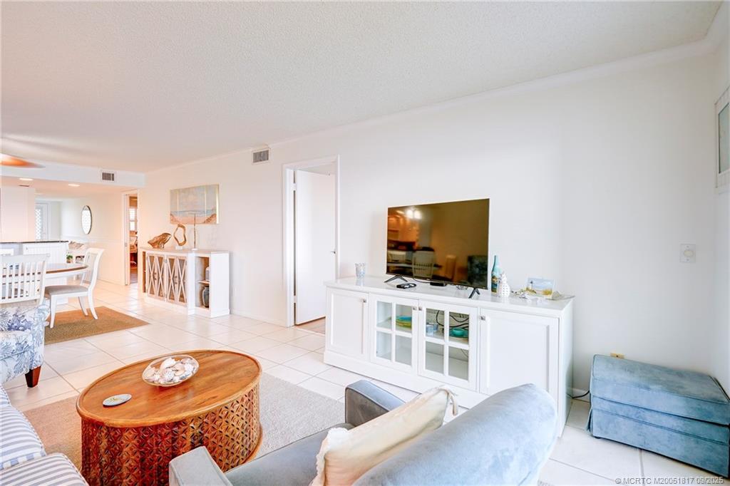 10 Northeast Plantation Road, Unit 203 Stuart, FL 34996 - Photo 30 of 50 a living room with furniture and a flat screen tv