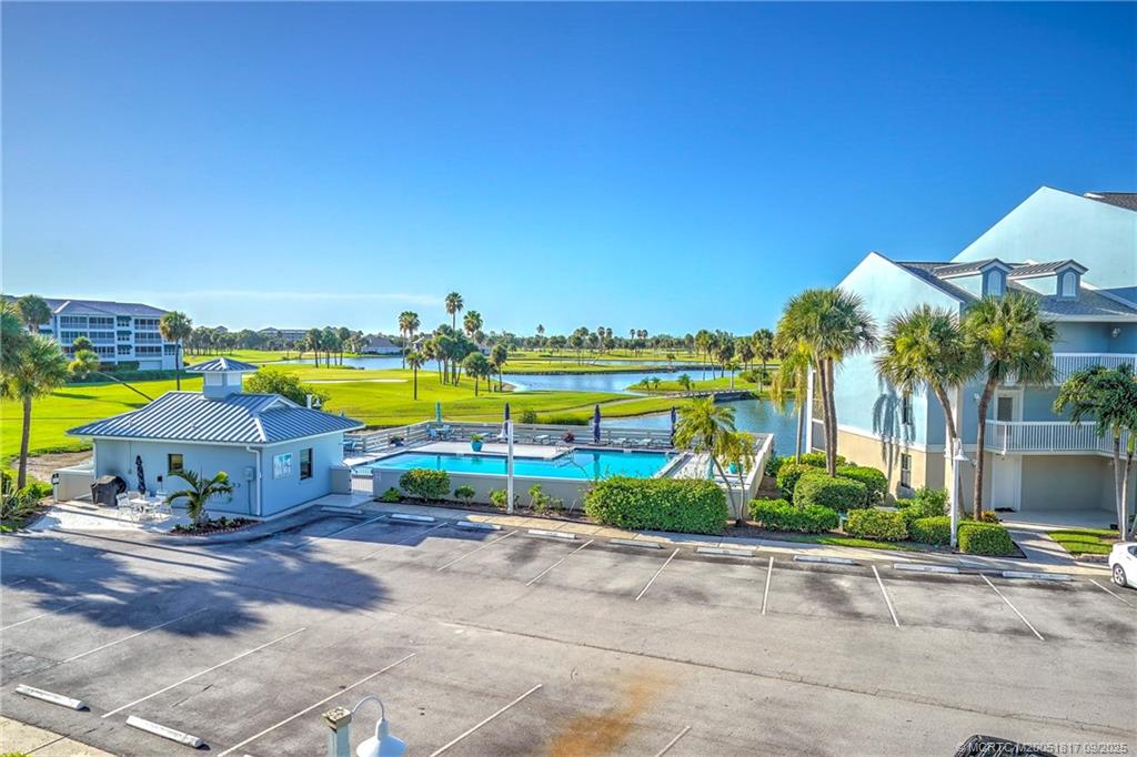 10 Northeast Plantation Road, Unit 203 Stuart, FL 34996 - Photo 8 of 50 a view of a swimming pool with a lawn chairs under an umbrella
