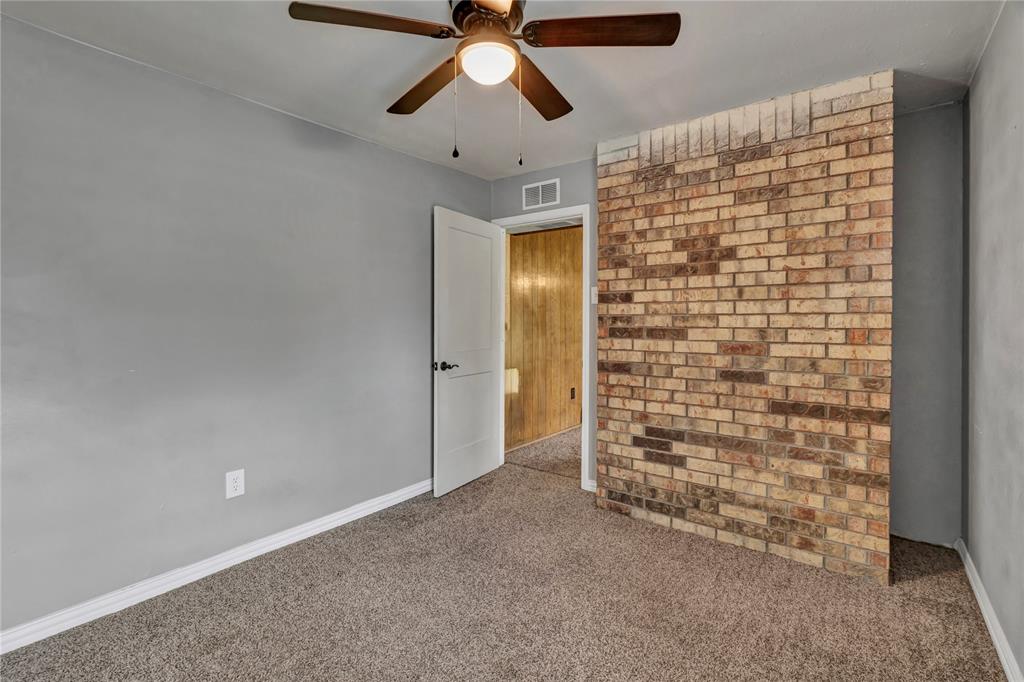 108 Prairie Creek Road Red Oak, TX 75154 - Photo 5 of 19 Interior space featuring a partial brick accent wall, neutral carpeting, and light gray painted walls