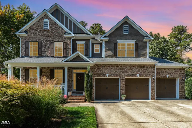 a front view of a house with yard and trees