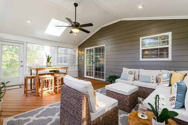 a living room with furniture two window and a dining table