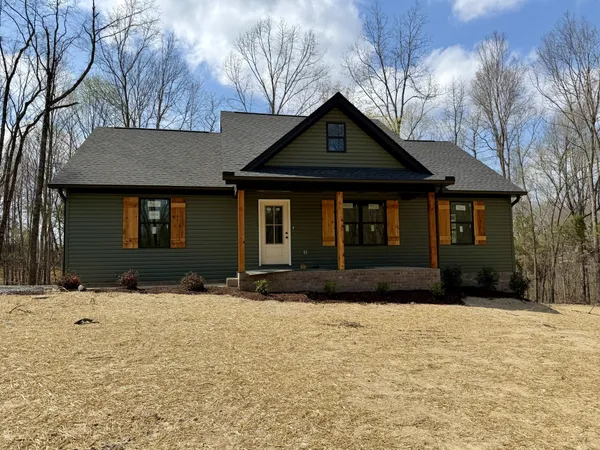 a front view of a house with a yard covered in snow
