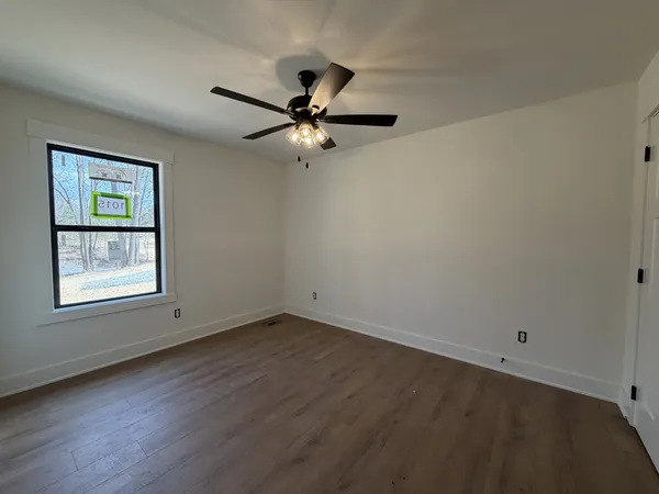 an empty room with a window and a fan