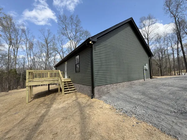 a view of a house with a yard and wooden fence