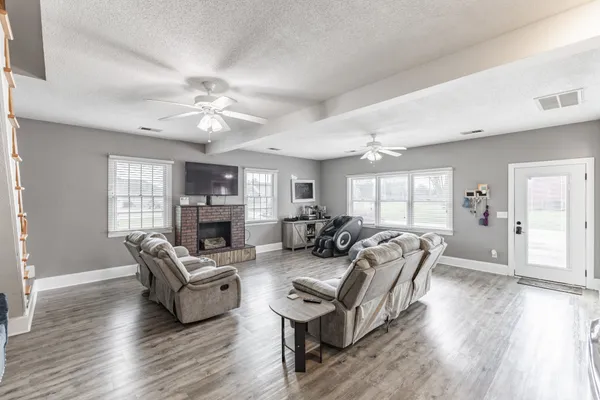 a living room with fireplace furniture and a wooden floor