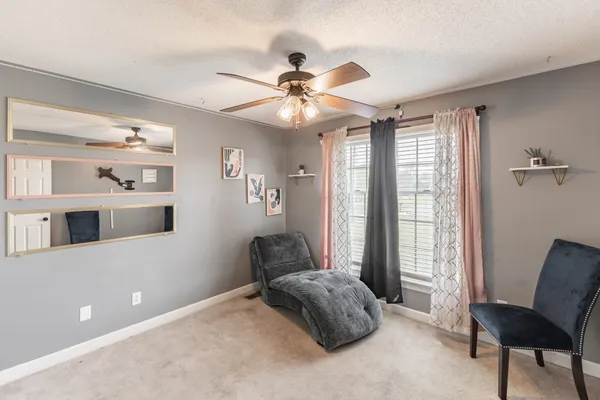 a living room with furniture and a ceiling fan